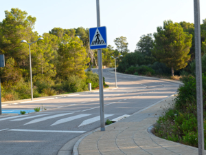 Calle bien mantenida en la urbanización Son Parc, Menorca, con aceras nuevas y farolas.