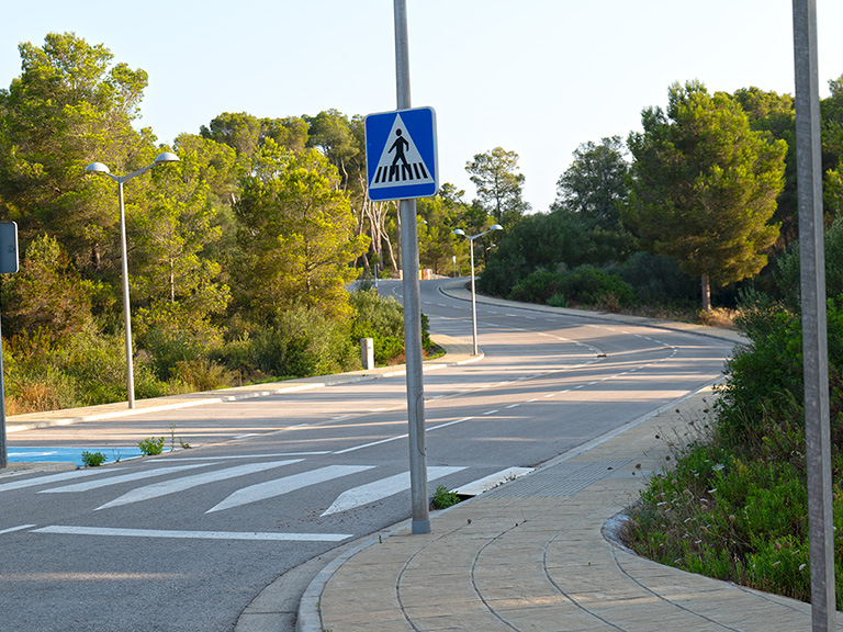 Calle bien mantenida en la urbanización Son Parc, Menorca, con aceras nuevas y farolas.